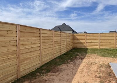 Construction of a fence in progress in front of a residential home.