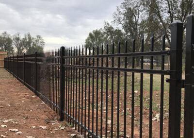 Black metal bars on the side of a fence.