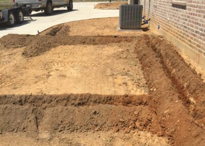 A truck parked in front of a dirt driveway.