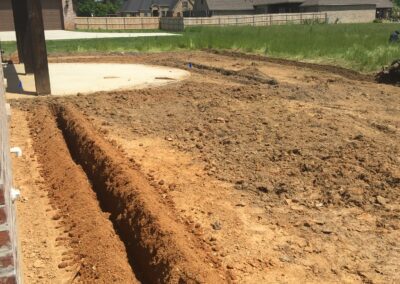 A person digging a dirt patch in the yard.