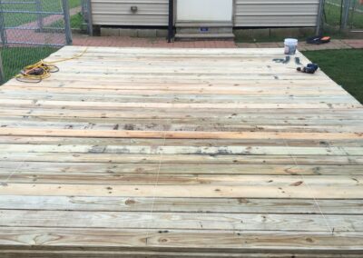 Wooden deck with shed in background.