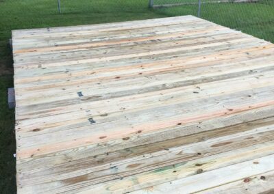 A wooden deck with a shed in the background.