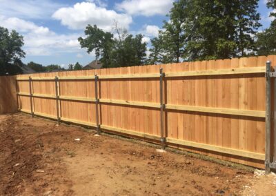 A garden fence made of wood with a metal gate.