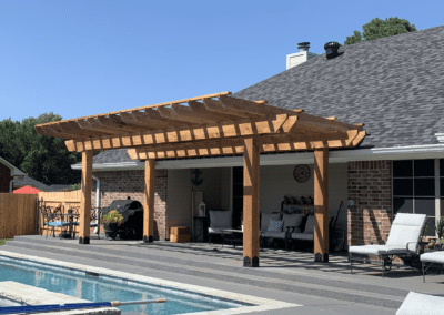 Outdoor space with a pool and a wooden pergola.