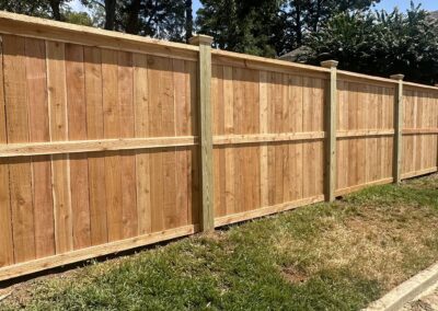 Image of a house with a freshly built fence being installed in the front yard.